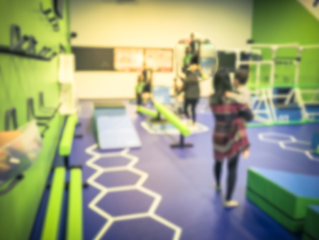 Blurry background parent and children playing at gym class in USAの写真素材