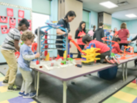 Blurry background children and parents playing indoor game together
