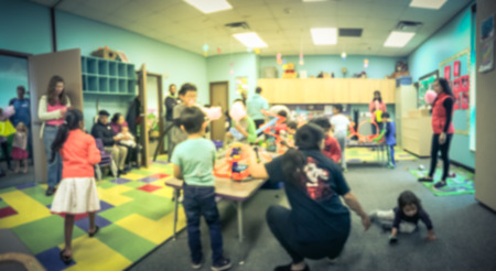 Panorama view blurred motion kids and parents enjoy playing toys car track racing indoor. Abstract background diverse, multicultural group of people gathering together near Dallas, Texas, USAの写真素材