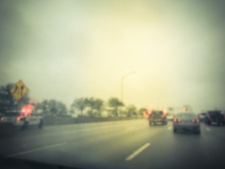 Blurred motion road accident on wet rainy day near Dallas, Texas, USA. Fire trucks and police car support and rescue injured people. Bad driving condition and severe weather concept