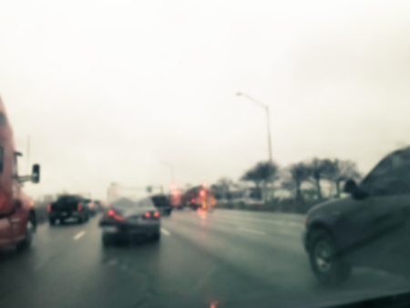 Vintage tone blurred motion road accident on wet rainy day near Dallas, Texas, USA. Fire trucks and police car support and rescue injured people. Bad driving condition and severe weather conceptの写真素材