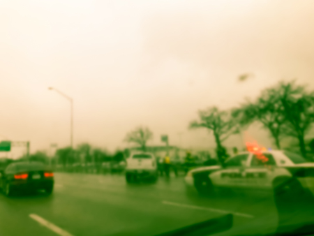 Vintage tone blurred motion road accident on wet rainy day near Dallas, Texas, USA. Fire trucks and police car support and rescue injured people. Bad driving condition and severe weather conceptの写真素材