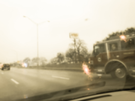 Blurred motion road accident on wet rainy day near Dallas, Texas, USA. Fire trucks and police car support and rescue injured people. Bad driving condition and severe weather conceptの写真素材