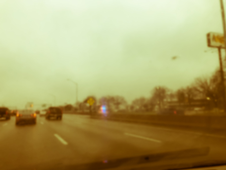 Vintage tone blurred motion road accident on wet rainy day near Dallas, Texas, USA. Fire trucks and police car support and rescue injured people. Bad driving condition and severe weather conceptの写真素材