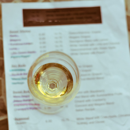 Vintage tone top view a glass of sweet white wine and tasting menu with price at local winery in North Texas, Americaの写真素材