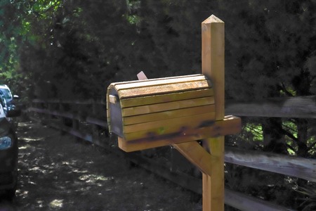Wooden mailbox near street with cars at  farm fence in Texas, USAの写真素材