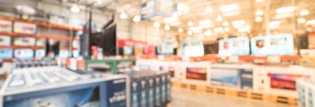 Panoramic blurry background row of modern TVs at electronic department of wholesale storeの写真素材