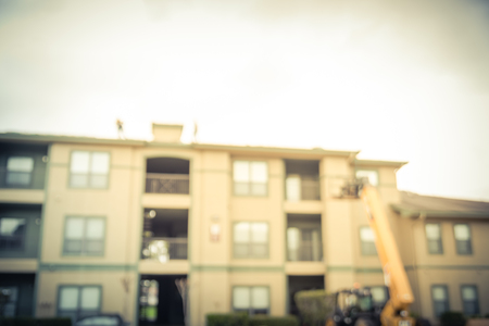 Blurry background roof replacement in progress at apartment building in USA