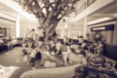 Filtered image blurry background diverse kids playing at indoor soft playground inside shopping mall
