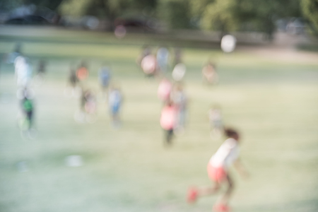 Filtered image blurry background children running on grass lawn at the park in Americaの写真素材