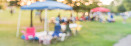 Panoramic view blurry background group of family members enjoy camping at local parkの写真素材
