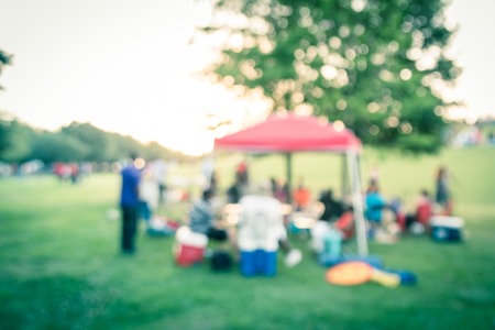 Filtered image blurry background group of family members enjoy camping at local parkの写真素材