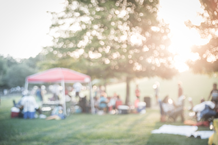 Filtered image blurry background group of family members enjoy camping at local parkの写真素材