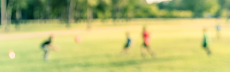 Panoramic view blurry background Latin America boys playing soccer at park during sunsetの写真素材