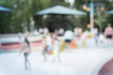 Filtered image blurry background diverse children playing at water splash padの写真素材