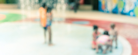Panorama view blurry background parents and kids enjoy water splash pad at summer timeの写真素材