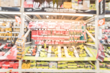 Blurred wide aisle power tool combo kits at hardware store in America. Abstract selection of pneumatic brad nailer, drill and driver, saw, circular, brushless, framing, straight, gauge cordless.の写真素材