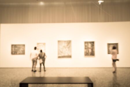 Filtered image blurry background people looking at fine art display at museum in USAの写真素材