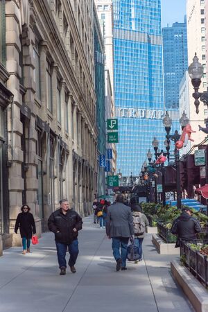 People walking along North Wabash Avenue with Trump hotel brand in distanceのeditorial素材