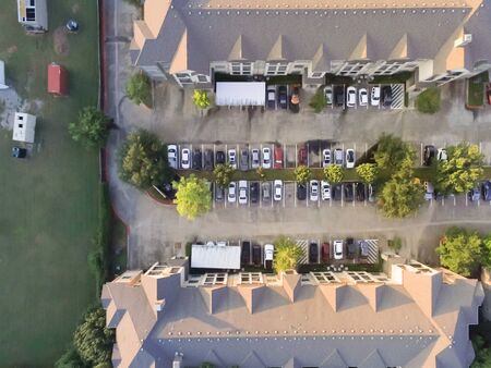Top view apartment building complex near vacant land with containers at sunset in Houston, Texas, USA. Top of rental units property with swimming pool and outdoor parking lotsの写真素材