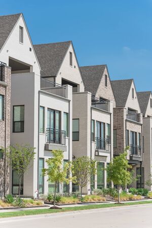 Close-up porch entrance of brand new row of three story single family houses in Richardson, North Dallas. Modern design of urban living residences with side private courtyards, nice trim landscapeの写真素材