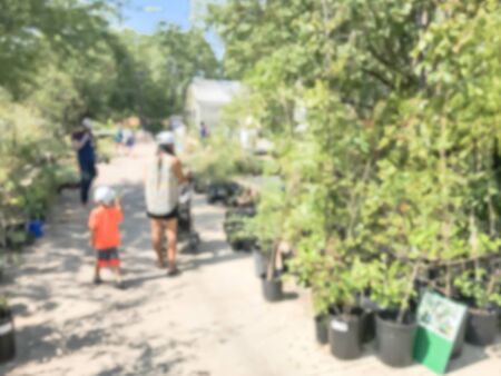 Motion blurred customers shopping for wide varieties of yard plants at plant sale event in Dallas, Texas, America. Garden with green house show and tourの写真素材
