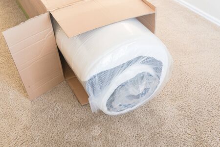 Close-up top view roll-packed spring mattresses unbox on carpet floor backgroundの写真素材