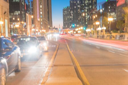 Motion blurred busy traffic at Wacker Dr street in downtown Chicago at evening time. Beautiful modern cityscape view of skyline, skyscraper buildings and light trails at blue hour, dusk.の写真素材
