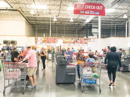 DALLAS, TX, US-OCT 19, 2019: Busy customers at self-checkout kiosks area of Costco in Churchill Way, Dallas. This option available at 125 wholesale stores to help reduce long linesのeditorial素材