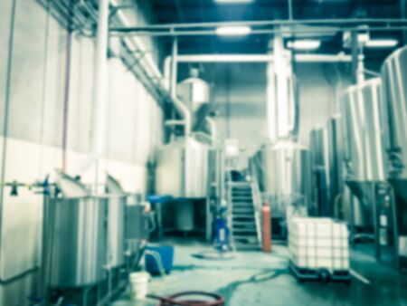 Abstract blurred beer brewing tanks at local brewery company in North Dallas, Texas, America. Shiny stainless steel beverage storage container equipmentsの写真素材