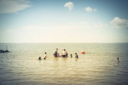 Blurred crowd of people enjoy swimming in a sunny day on beach at La Porte, Texas, USA. Summer holiday concept. Outdoor activities, healthy lifestyle used for concept backgroundの写真素材