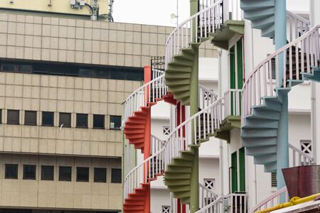 Bugis city skylines and colorful spiral staircases at the back of traditional Chinese shop houses in Singapore.の写真素材