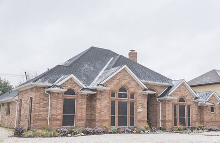 Typical bungalow house under winter snow cover near Dallas, Texas. Middle class residential home in America.の写真素材