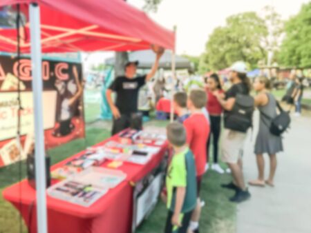 Blurred image diverse kids watching magic show small magical booth stand at local event fair near Dallas, Texas, Americaの写真素材
