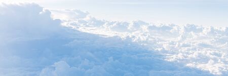 Panorama beautiful and unusual Altocumulus or Cirrocumulus cloud formation seen from airplane window at sunrise. Skyline view above the clouds from the airの写真素材