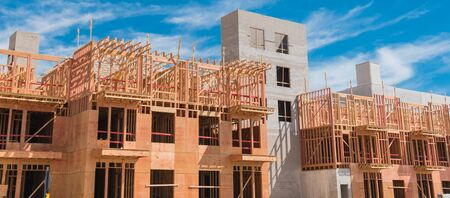 Panorama view multistory condominium under construction with wooden lumber timber framework and...