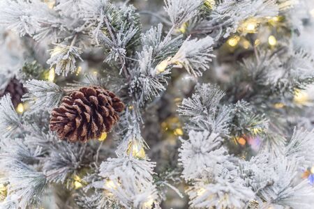 White artificial Christmas tree with pine cones and multi-lights pre-lit. Xmas decoration supplies on display at home improvement store in Texas, Americaの写真素材