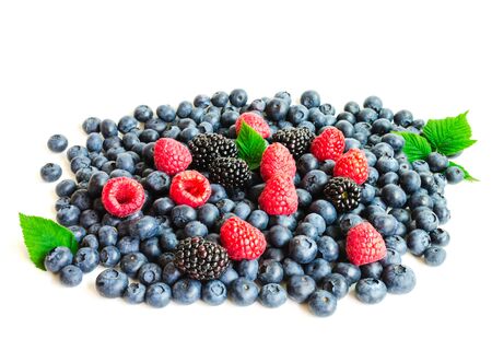Collection of fresh berries with green leaves isolated on white background. Fresh picked organic pile of blueberries, raspberries, blackberriesの写真素材