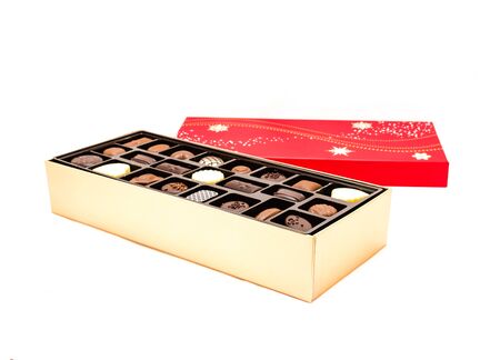 Open chocolate box with variety of truffle isolated on white background. Festive chocolate confectionery for holidays and special eventsの写真素材