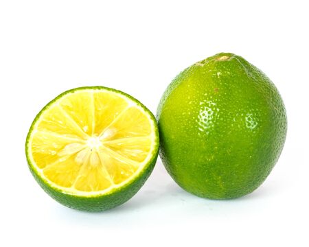 Close-up view a whole and slice cut of fresh green organic raw limes citrus isolated on white background with clipping path.の写真素材