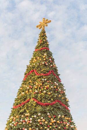 60 foot Christmas tree with snowflake top, ornament balls and efficient LED lights display at sunset. Typical Xmas decoration at upscale shopping center in Texas, Americaの写真素材