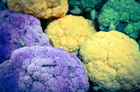 Green, yellow and purple cauliflower heads at farmer market in Puyallup, Washington, America. Close up full frame healthy vegetable display on grocery standの写真素材