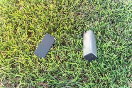 Typical smart phone and  speaker on grass lawn nature environmentの写真素材