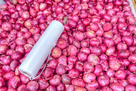 Bunch of fresh raw purple shallots with wrap at market stand in Little India, Singaporeの写真素材