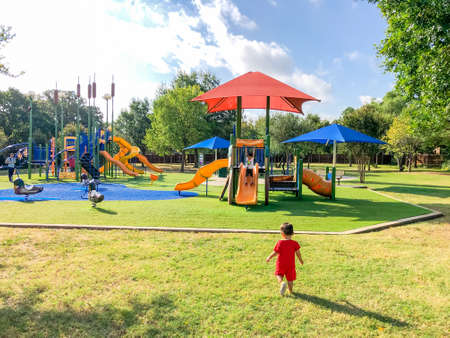 Rear view Asian toddler boys playing at neighborhood playground with sun shade sails in Flower Mound, TX, USの写真素材