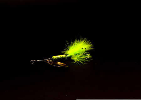 Inline Spinner Lure with three hooks spinnerbaits isolated on black background. Pulsating hackle tail with high flash, easy spin blade fishing tackleの写真素材