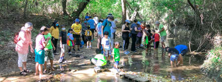 COPPELL, TX, US-OCT 9, 2021: Panorama view diverse people attending the Geology and Fossils program with geologist along the creek in nature park. Kids friendly outdoor learning experienceのeditorial素材