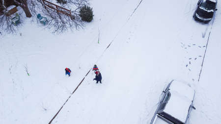 Children in warm clothes playing with snow on residential street near Dallas, Texas, USA. Residential street and sidewalk with parked cars covered in thick snow after historic blizzard stormの写真素材
