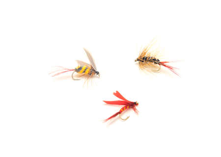Three fly fishing lures in different files, colors and hook sizes isolated on white background....