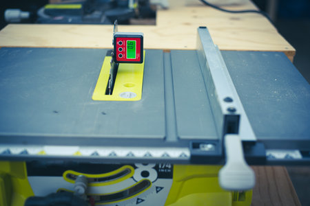 Brand-new table saw with digital level box inclinometer showing 0-degree angle attaches to steel...